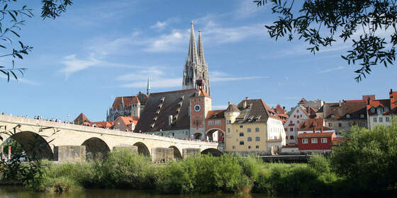 Eine malerische Steinbrücke überspannt den Fluss vor der Altstadt von Regensburg.